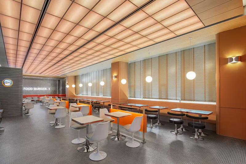 Long dining room with vertical slatted blinds along window wall and sphere pendant lights overhead