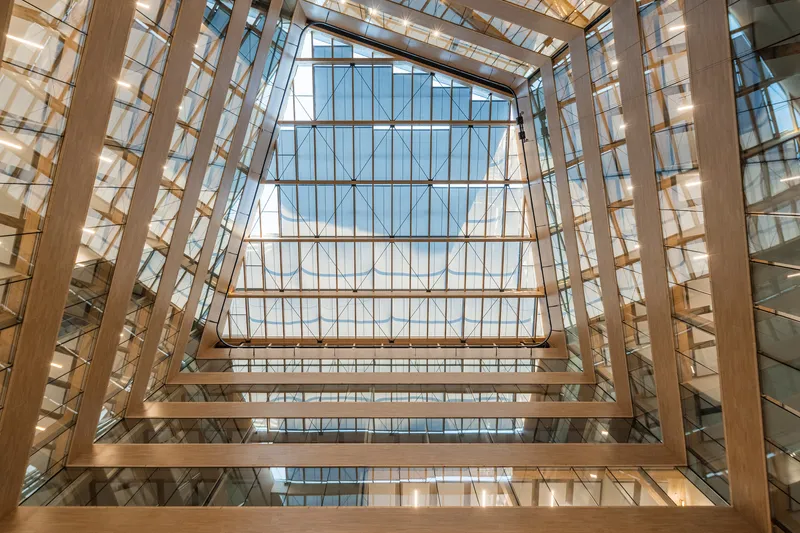 Looking up through the timber-framed atrium to the peaked glass skylight above