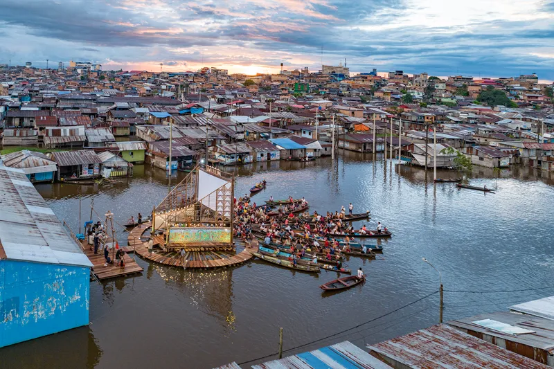 Aerial view of the floating stage and circular platform surrounded by boats at sunset