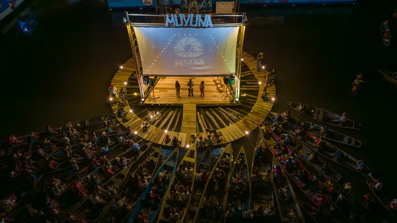 Aerial view of the timber floating platform with projection screen and radial deck seating at night