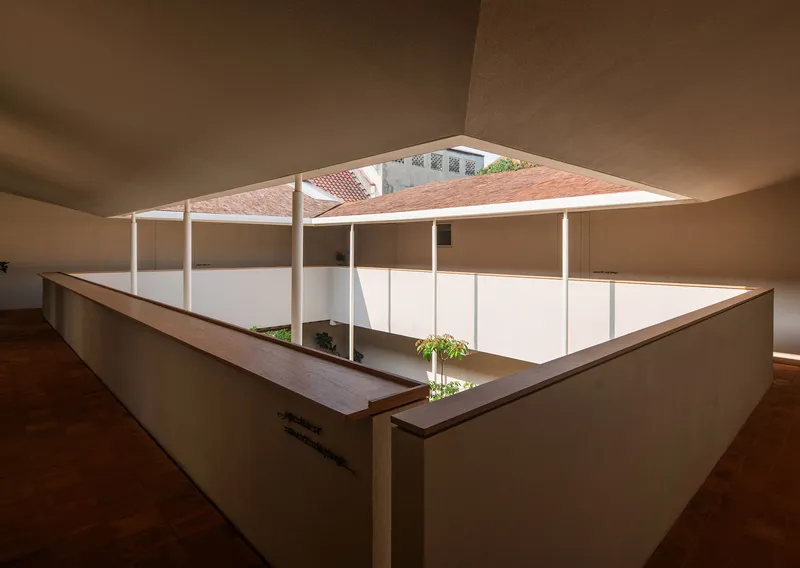 Interior courtyard viewed from an upper corridor with timber bench and planted bed below