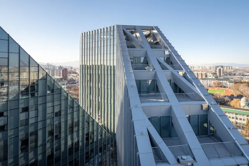 Aerial view of the zigzag structural bracing across the tower facade at sunset
