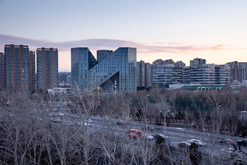 Distant view of the angular towers rising above leafless trees at dusk