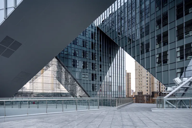 Triangular void cut through the building mass framing glass facades and surrounding towers