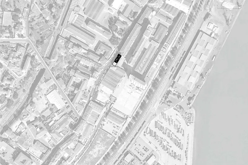 Site plan drawing showing a single building footprint highlighted in black within a dense urban block