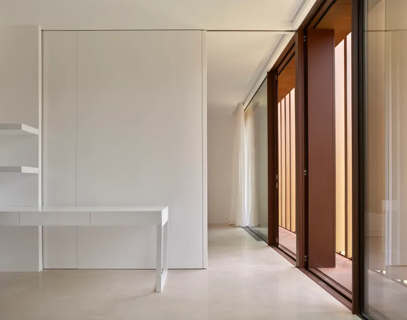 Interior space with sliding wood-framed glazed doors and white built-in desk