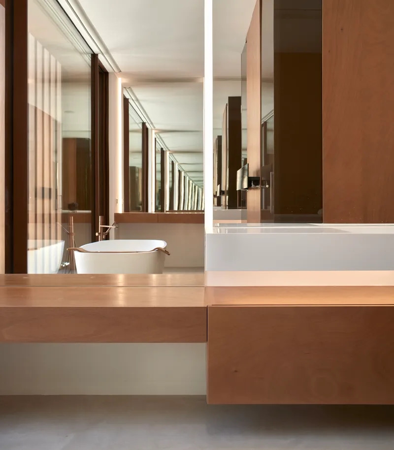Floating timber vanity with vessel sink beneath mirrored wall reflecting wood slat screen