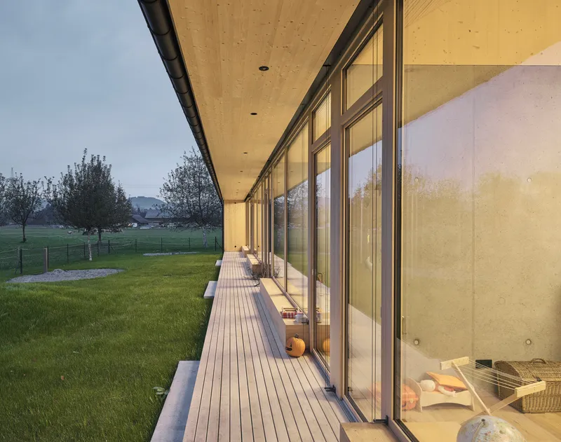 Exterior terrace with wood decking and sliding glass doors at dusk