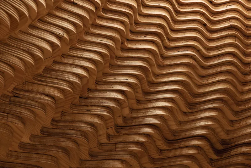 Close-up of the undulating laminated wood surface showing shadow and grain