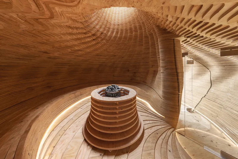 Interior view of the laminated wood sauna chamber with central heater and radial benches