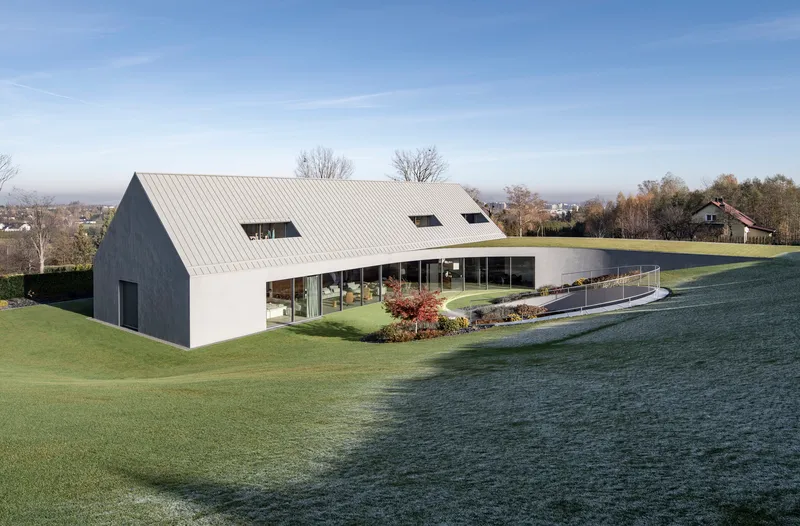 Garden facade with continuous glazing below the sloped metal roof on a frosty morning