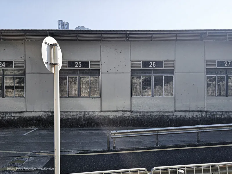 Concrete facade with numbered bays and horizontal ventilation grilles beneath an overcast sky