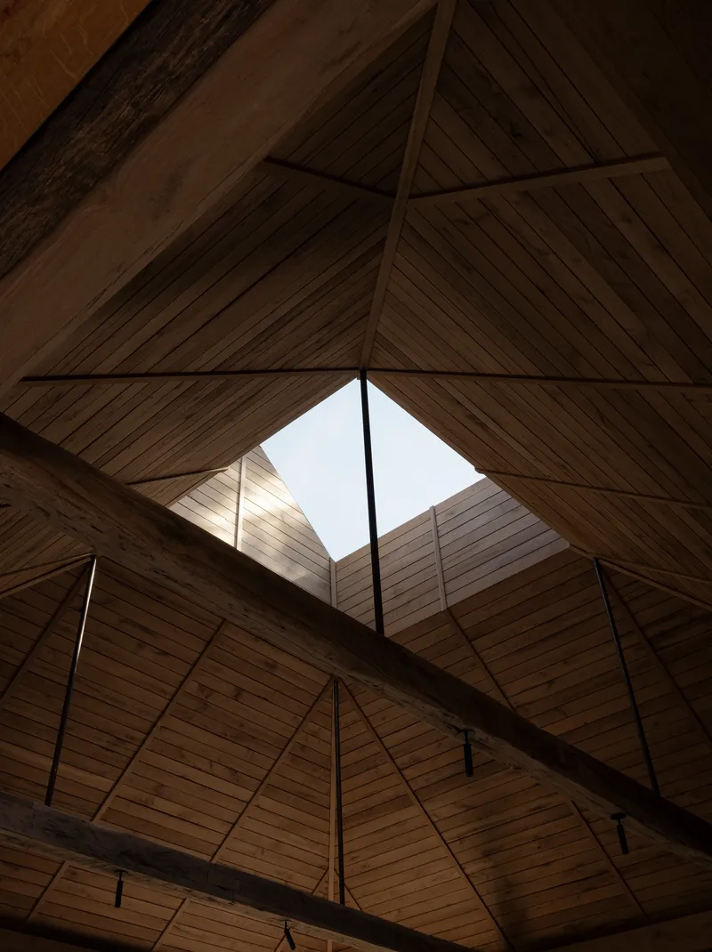 Interior view of the pitched timber ceiling with exposed beams and central skylight above