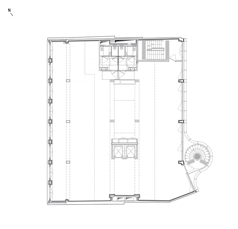 Floor plan drawing showing an open space with central restrooms, stair, and a curved corner staircase