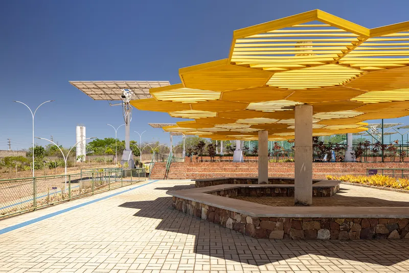 Yellow canopy detail supported by cylindrical concrete columns with water tower visible in background
