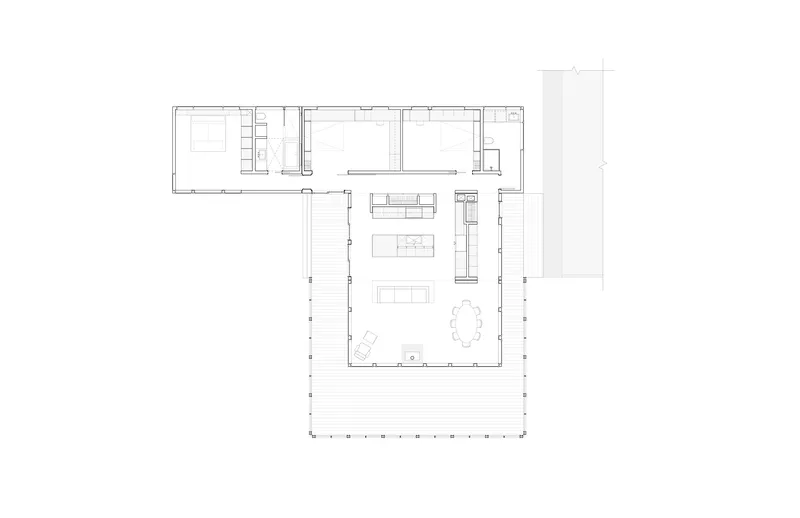 Floor plan showing L-shaped layout with open living area and bedroom wing flanked by wraparound deck