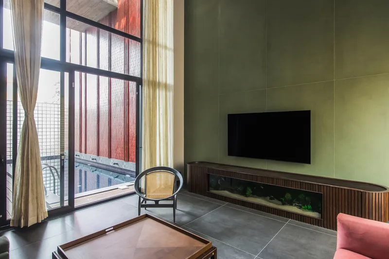 Living room with yellow paneled wall and glass-block balcony doors filtered by pink and beige curtains