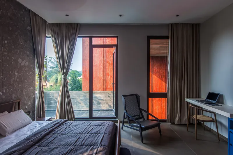 Bedroom with translucent orange screens glowing in the balcony door and window at dusk