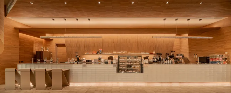 Long service counter with wood paneling and under-counter lighting in warm evening glow
