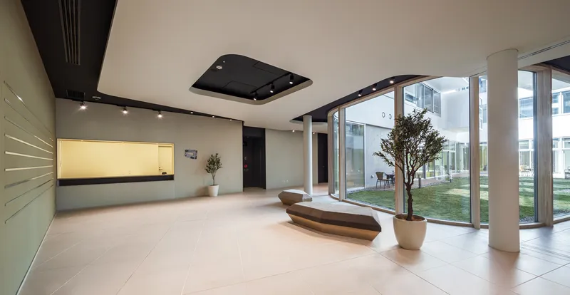 Interior lobby with large glazing overlooking an interior courtyard with a small tree