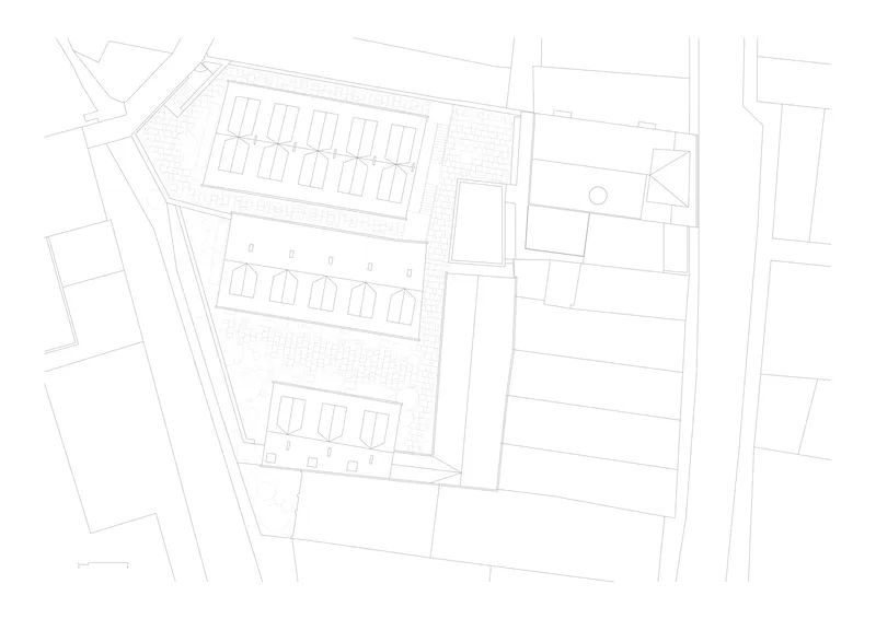 Site plan drawing showing three rows of pitched-roof townhouses on an angled lot with surrounding streets