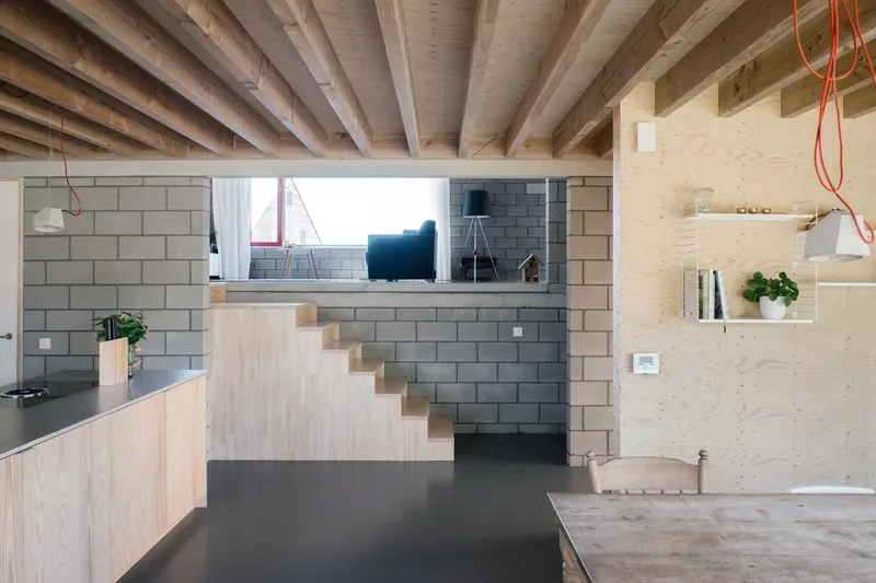 Interior view under exposed timber joists showing split-level arrangement and concrete block partition wall