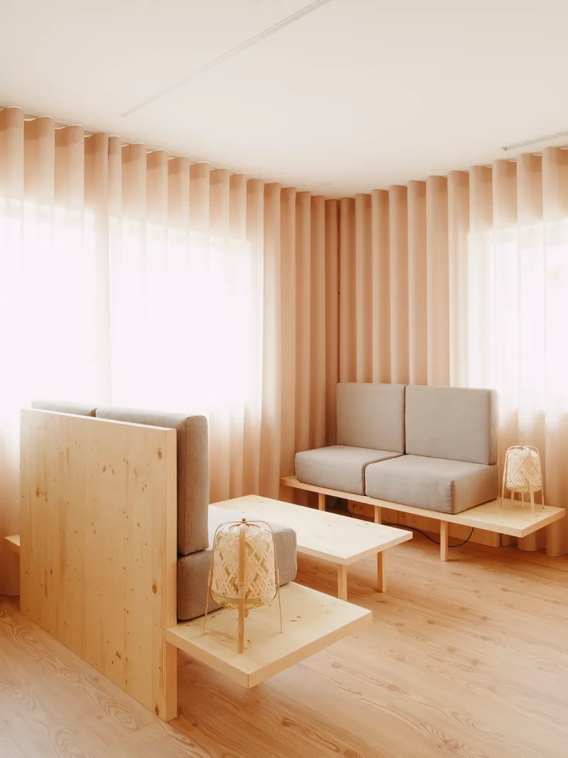 Plywood partition dividing the lounge area with wicker lanterns on low timber platforms