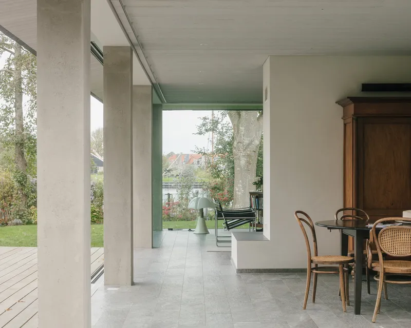 Covered porch looking through concrete columns toward the garden and water beyond