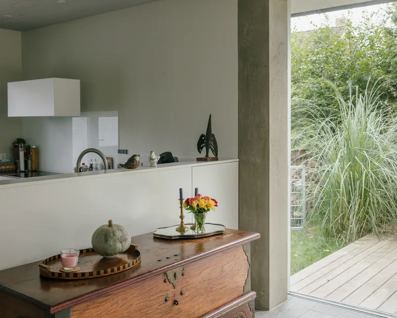 Kitchen with cast concrete column beside an open door to the garden terrace
