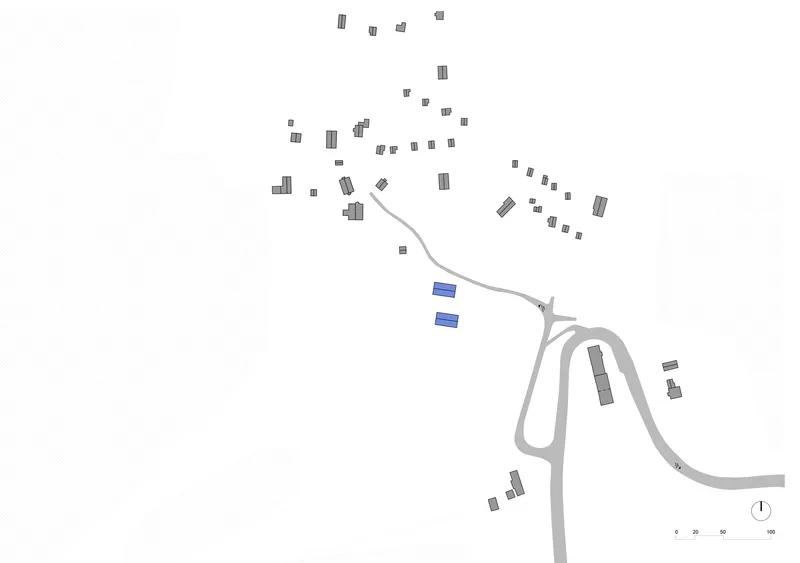 Site plan drawing showing two buildings highlighted in blue among scattered village structures and curving roads