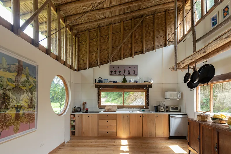 Kitchen with timber cabinetry beneath a bamboo-clad vaulted ceiling and exposed timber beams