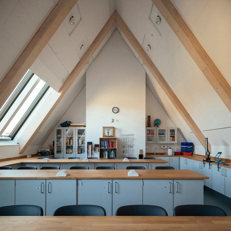 Laboratory benches beneath a vaulted ceiling with exposed timber rafters and a roof window