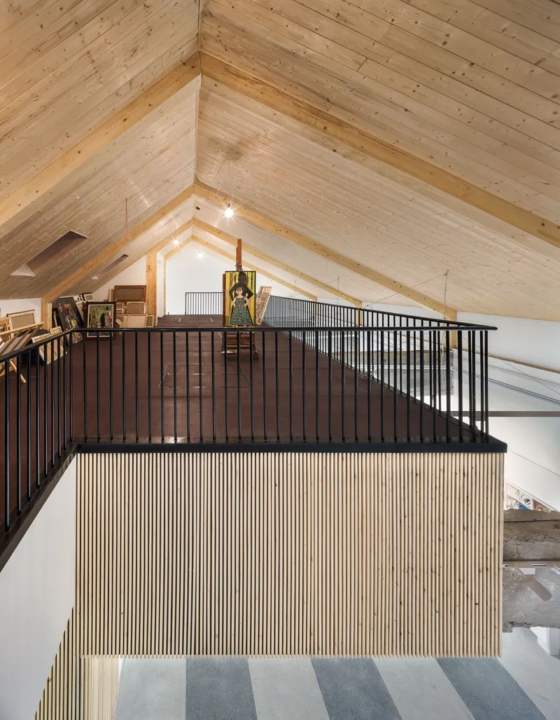 Upper level mezzanine with timber slat balustrade beneath a gabled timber ceiling with exposed beams