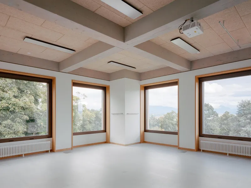 Corner room with coffered cork ceiling, four timber-framed windows and views to treetops and hills