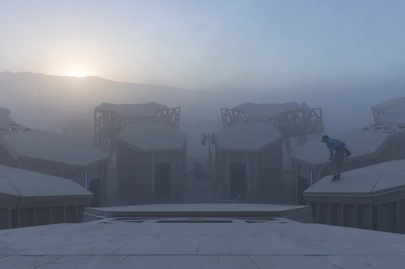 View of symmetrical timber structures with ornamental roof elements and a lone figure in heavy fog