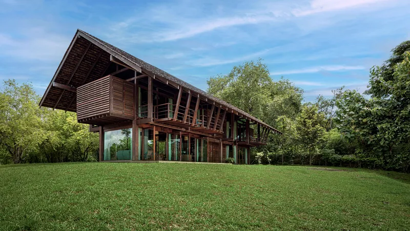 Side elevation showing the raised timber structure with exposed rafters and deep overhanging roof above a lawn