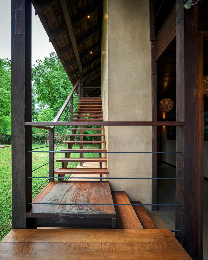 Interior view from timber stair landing showing polished plaster core wall and open tread staircase with steel railings