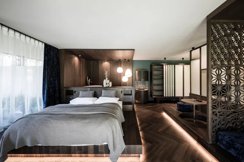 Guest suite with walnut platform bed, backlit base and patterned metal screen partition