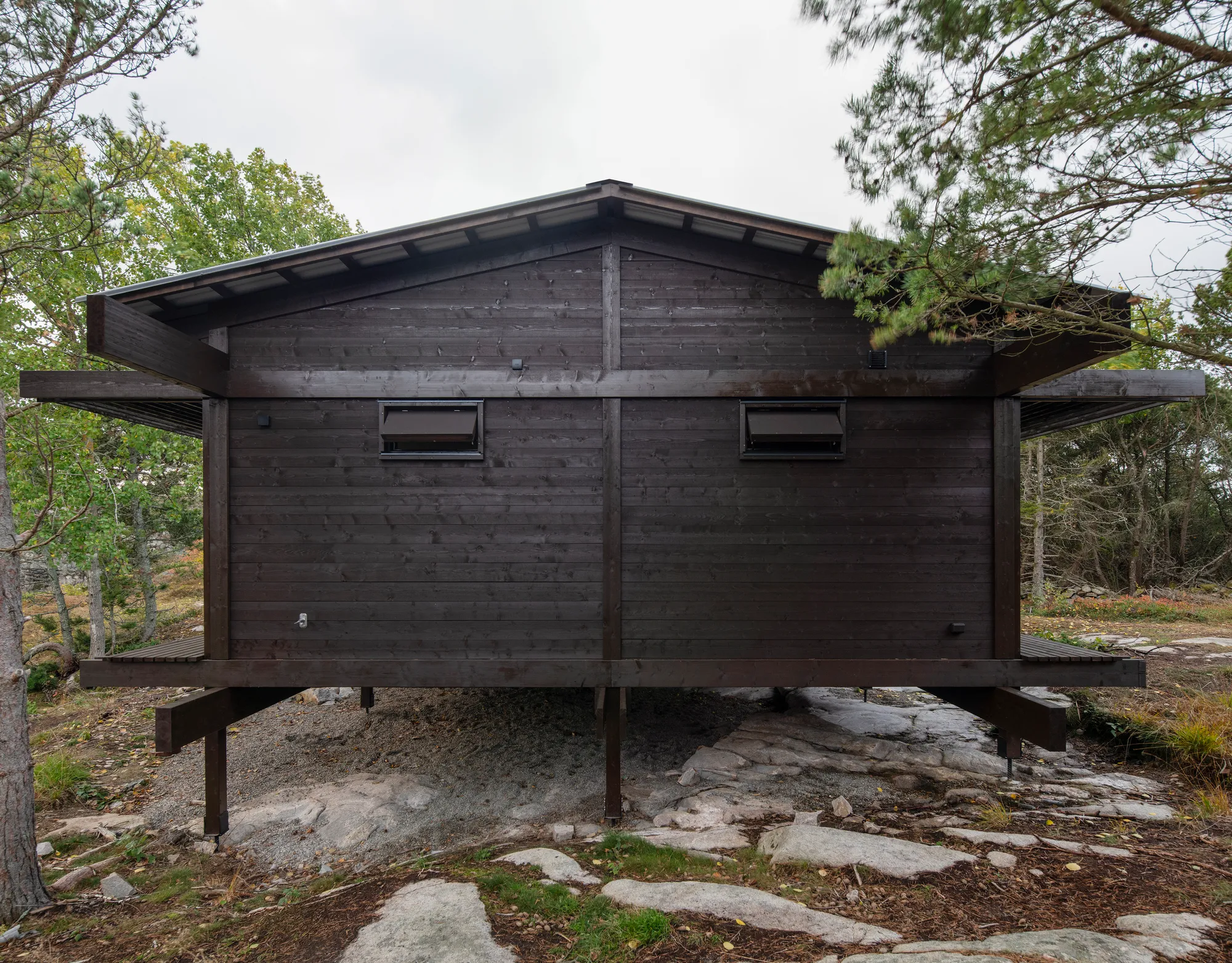 HelgessonGonzaga Raises a Tar-Coated Weekend Pavilion Above the Rocks of a Swedish Nature Reserve