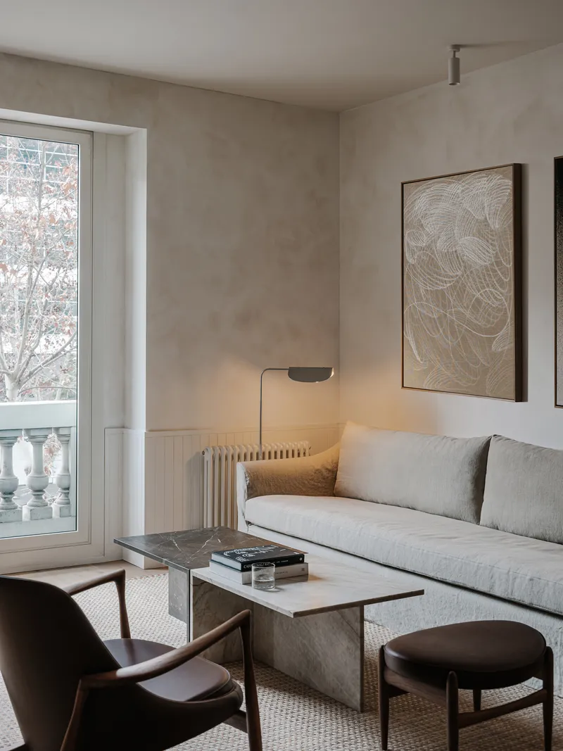 Sitting area with French doors opening to balcony overlooking bare winter trees outside