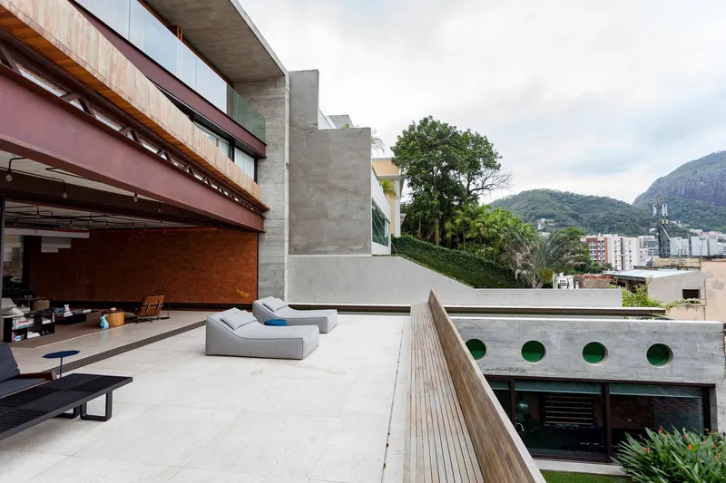 Rooftop terrace with concrete soffit and steel louvers overlooking mountains and trees