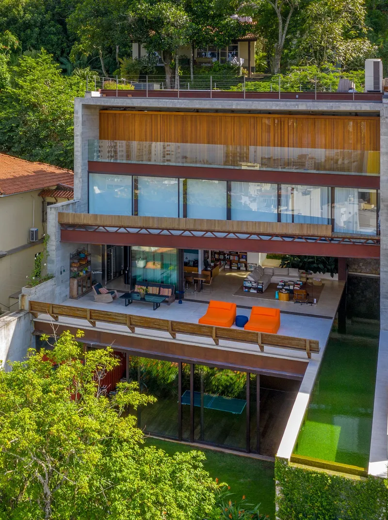 Facade showing staggered levels with timber louvers and rooftop garden beyond trees