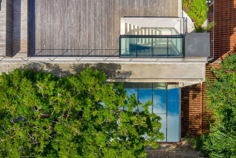 Aerial view of rooftop terrace with glass pavilion and weathered concrete deck