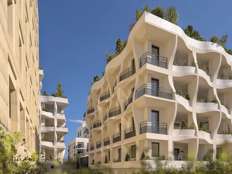 Courtyard view of the undulating white balconies with planted terraces under clear blue sky