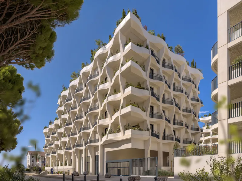 Street view of the wavelike facade with black railings and planted terraces against clear sky