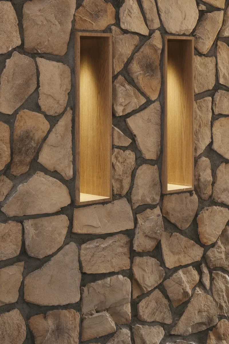 Two vertical illuminated niches recessed into an irregular fieldstone wall