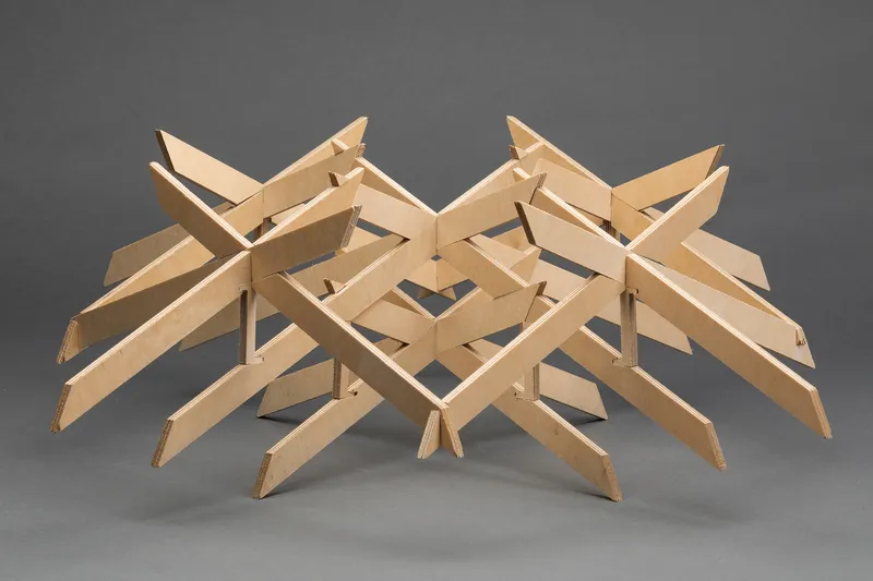 Plywood structural model with interlocking beams arranged in a radiating grid pattern