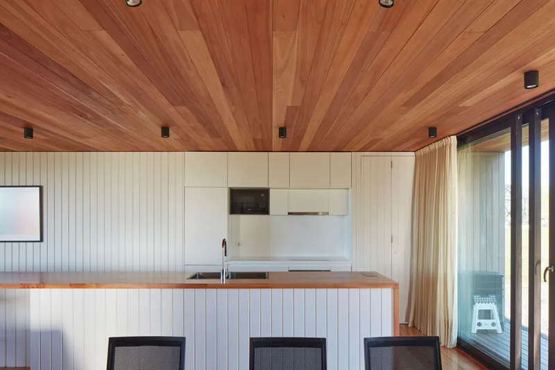 Kitchen counter with timber-lined ceiling radiating from a central spine beam