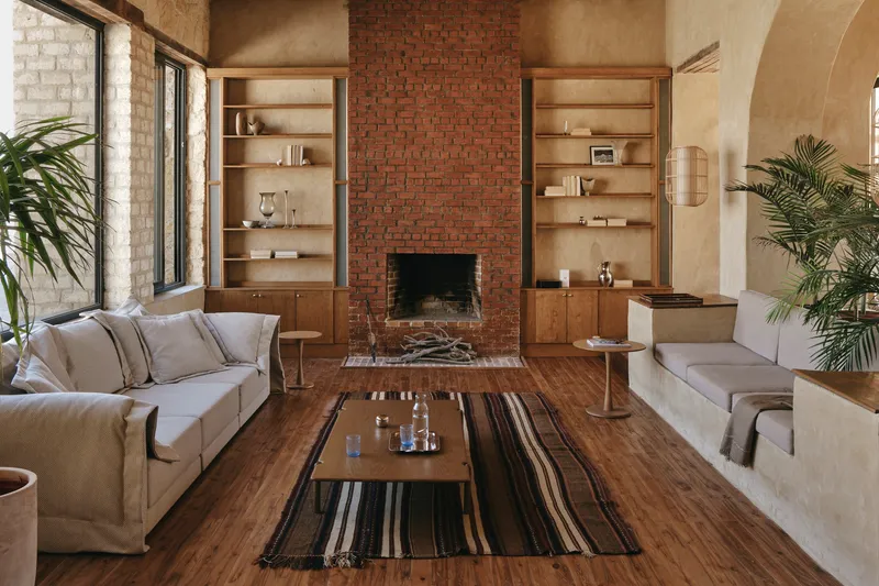 Living room with red brick fireplace flanked by built-in timber shelving