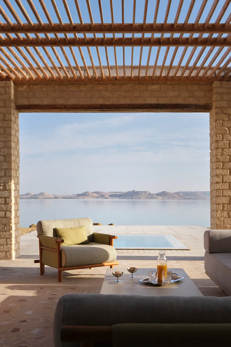 Timber pergola shading the terrace with views across the water to distant hills